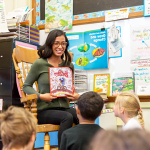 Photo of Idalee Nunez reading to a group of young children in a classroom.